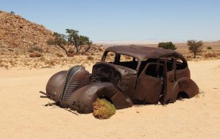 Un rottame di auto disperso nel deserto.