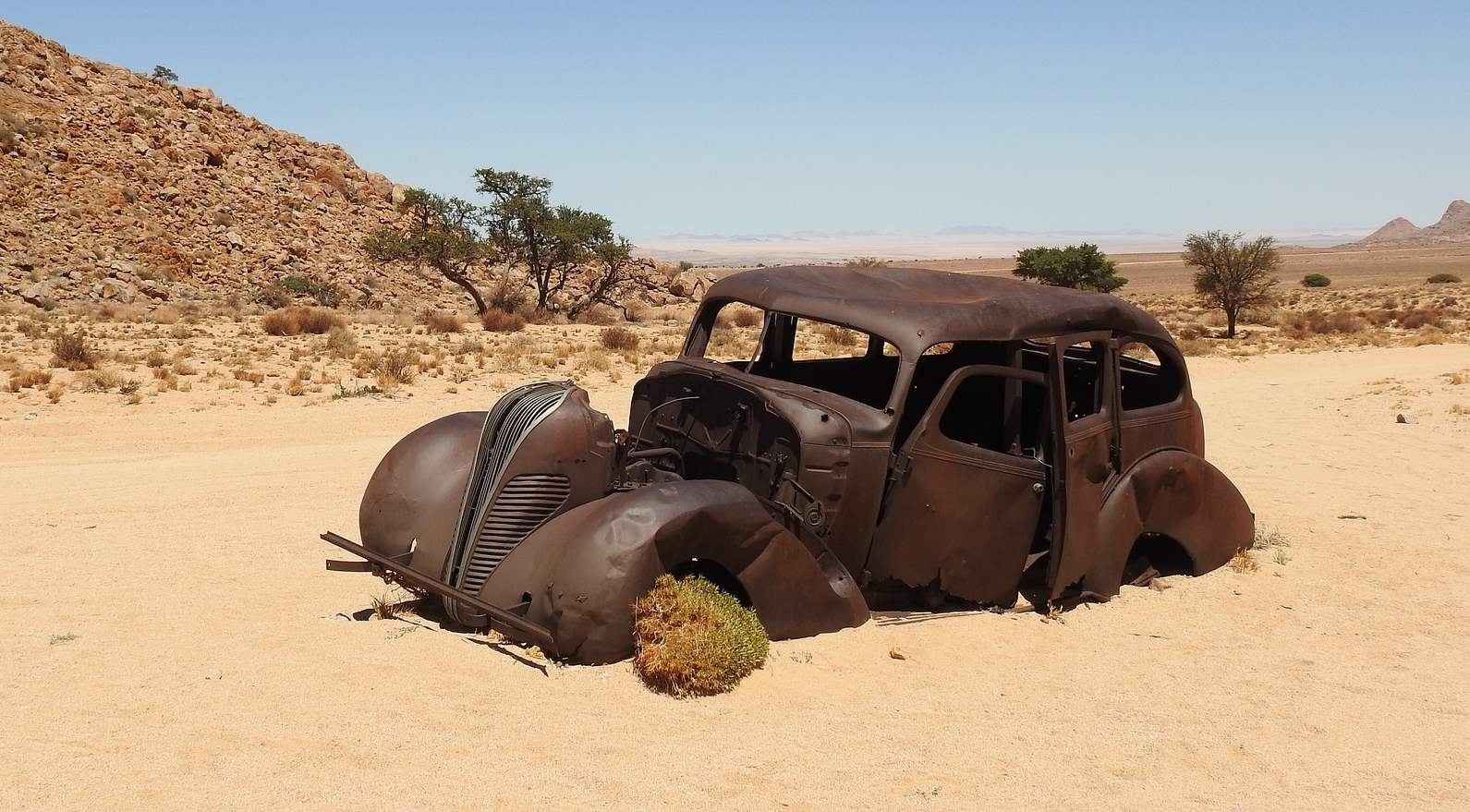 Un rottame di auto disperso nel deserto.